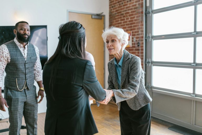 Woman in Black Dress Standing Beside Woman in Gray Cardigan